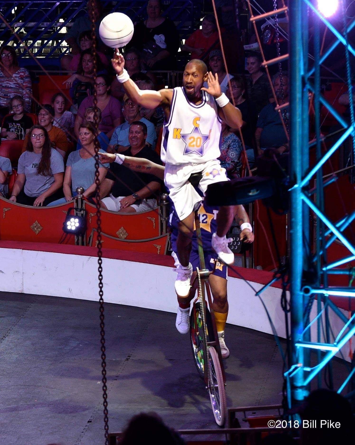 Kaseem Alamudeen balancing a basketball while riding a unicycle