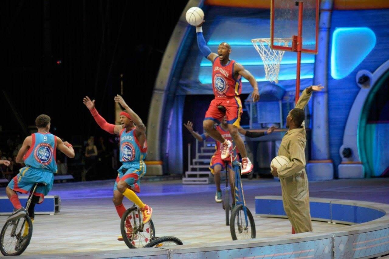 King Charles Unicycle Troupe performing live unicycle basketball in an arena